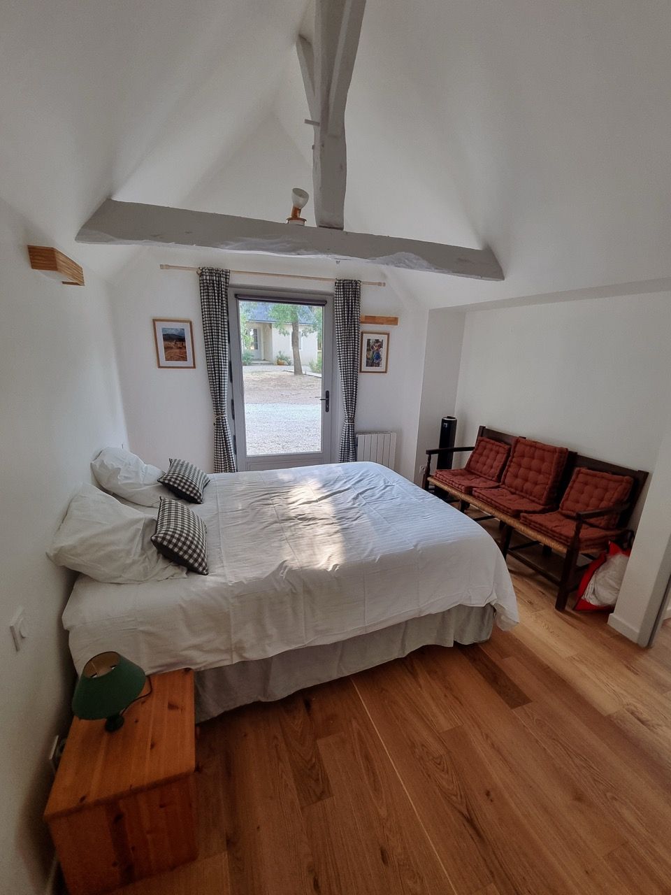 Chambre double et sa banquette aux coussins rouges