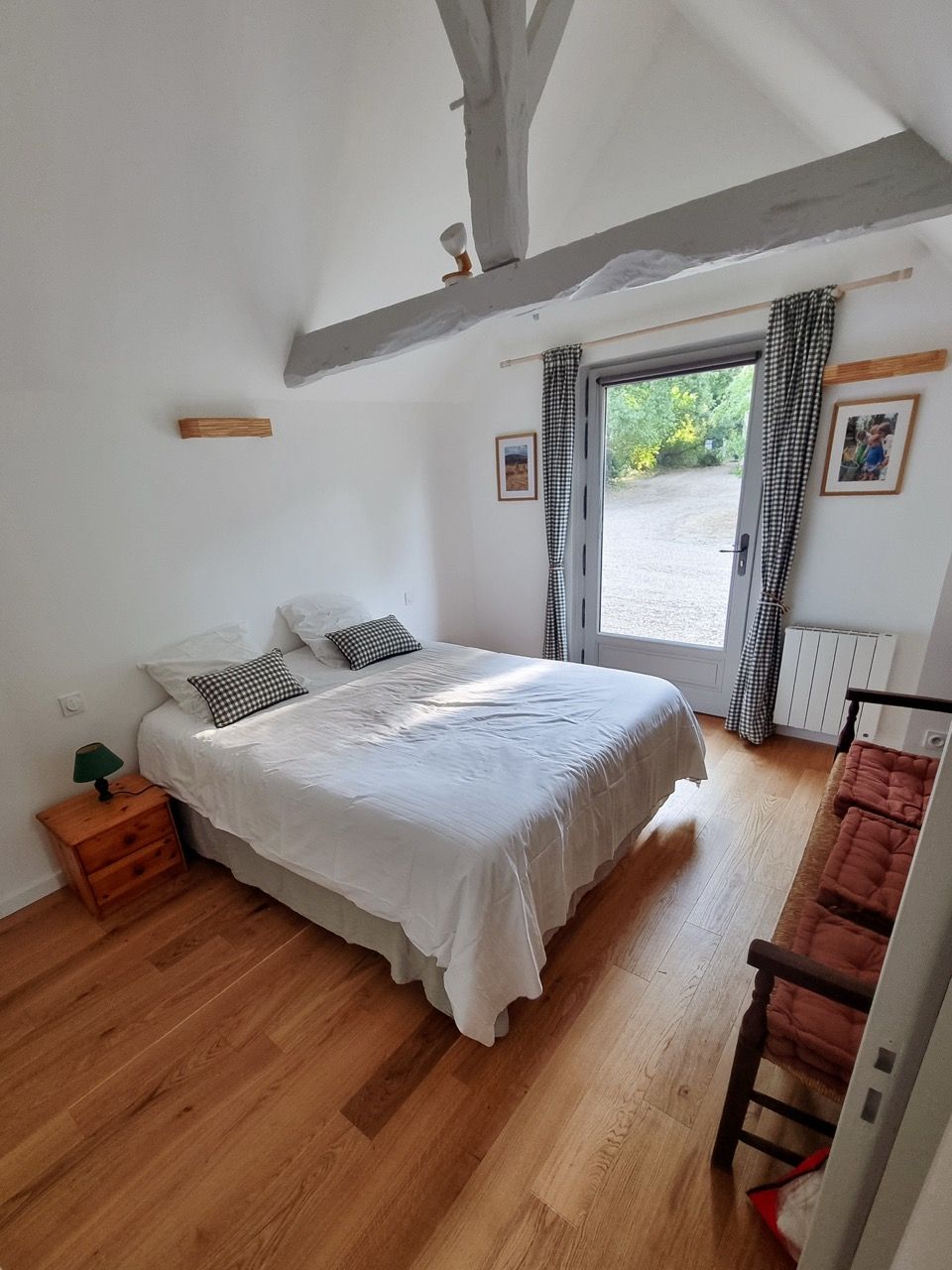 Chambre au parquet clair et porte-fenêtre sur le jardin