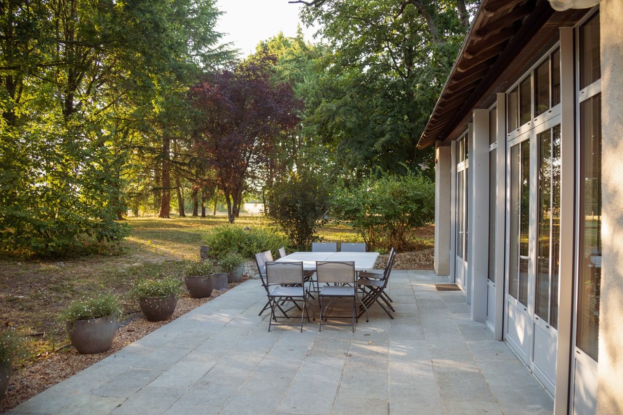 La terrasse dallée et sa grande table au matin