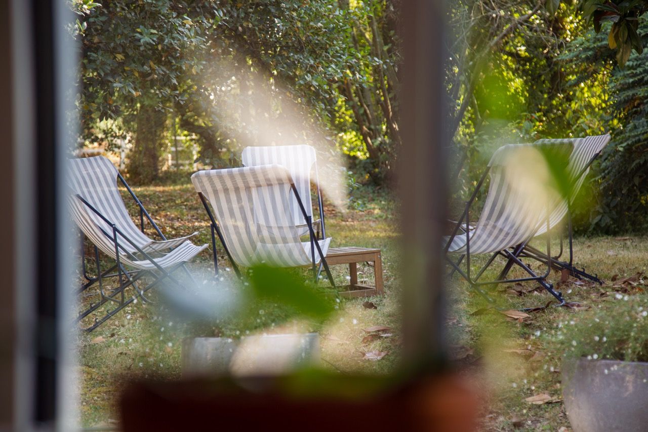 Transats rayés à l'ombre des arbres