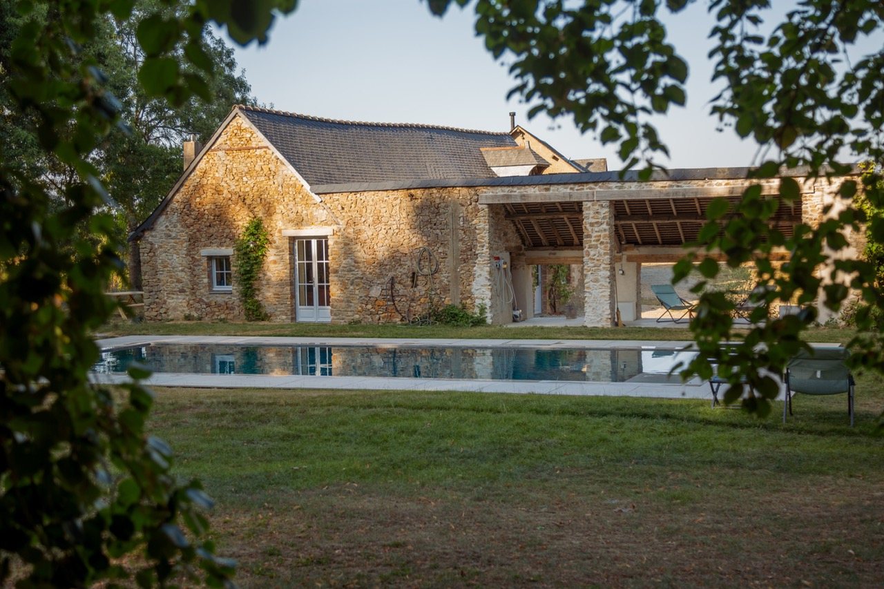 La grange de pierre et la piscine miroir au couchant